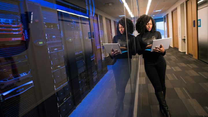 An engineer checking a tablet inside a server room