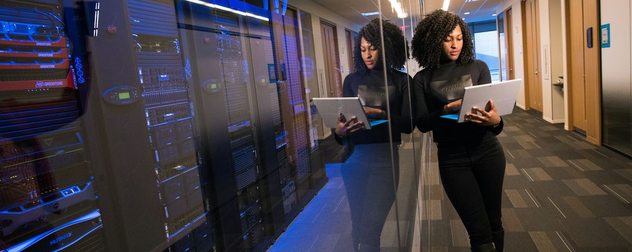 An engineer checking a tablet inside a server room