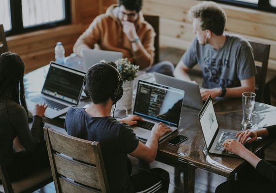 A small team working together on laptops around a table
