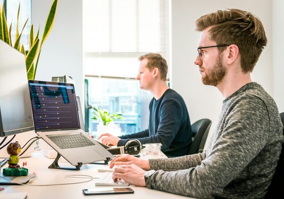 A developer at a desk keeping a website running on two monitors